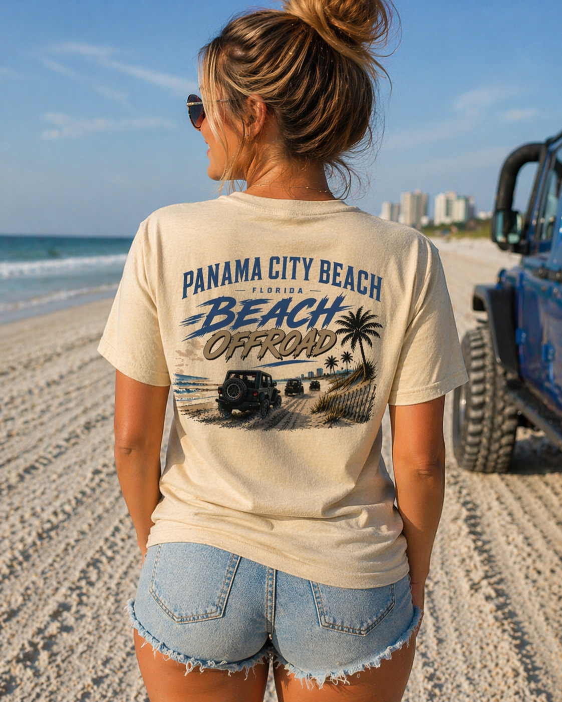 Woman wearing a Panama City Beach, Florida t-shirt by Beach Offroad on a beach with a Jeep in the background.
